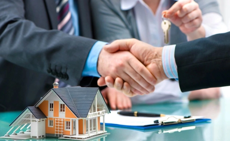 A group of people shaking hands over some keys.