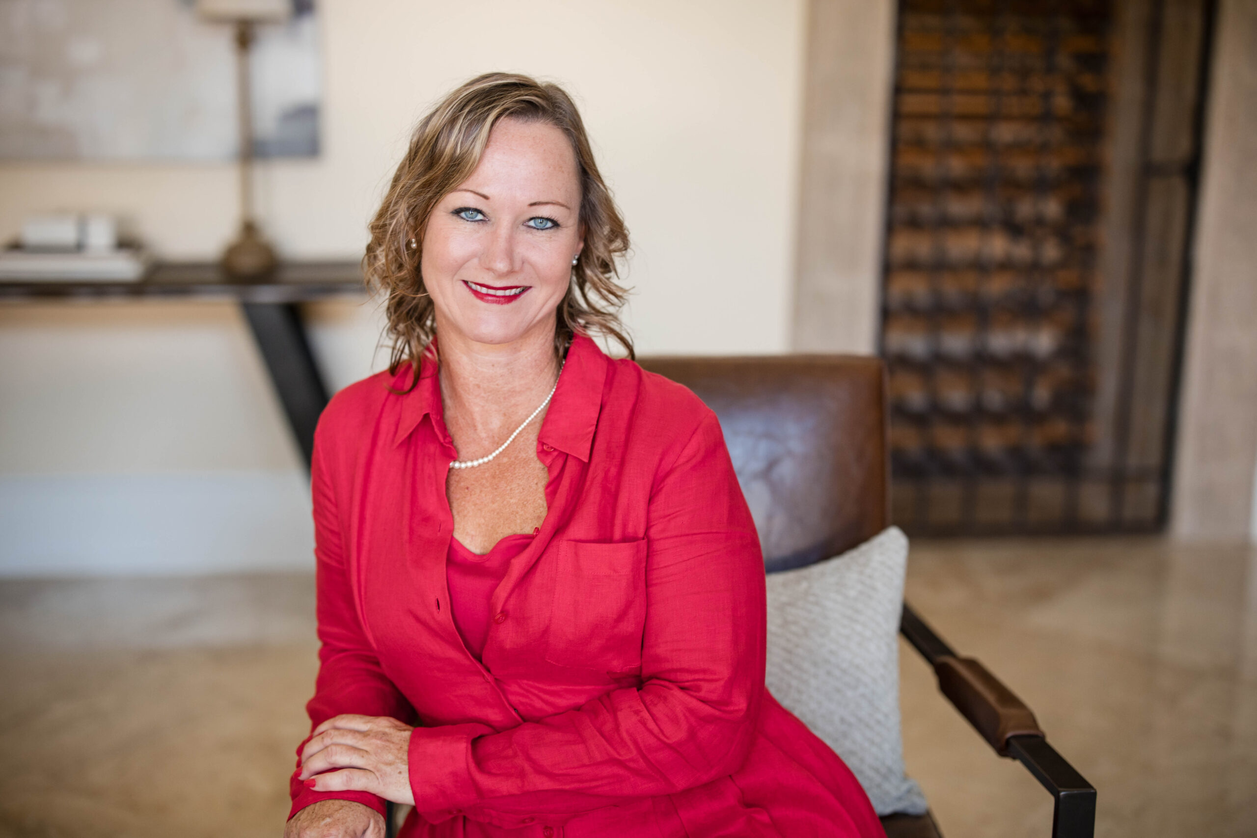 A woman in red shirt sitting on chair.