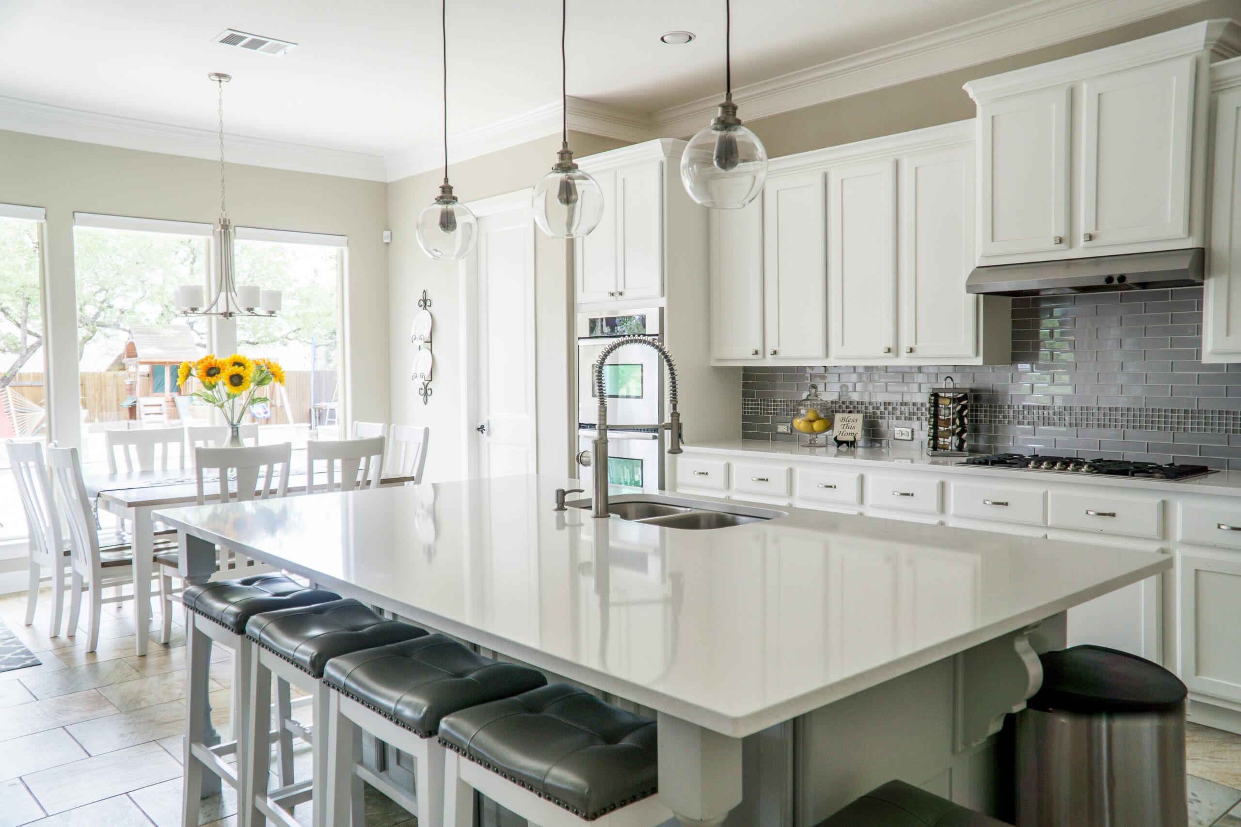 A kitchen with white cabinets and a large island.