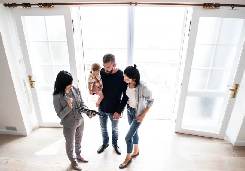 A group of people standing in front of a window.